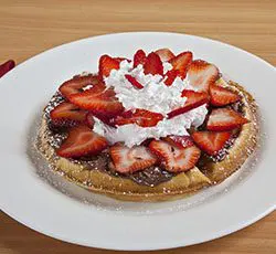 Delicious waffle topped with fresh strawberries