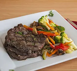 Steak served with sautéed vegetables